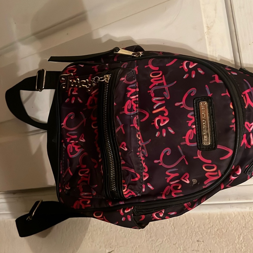 A juicy couture, mini backpack that is black, pink, and gold.